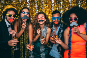 friends smiling in funny booth at company event